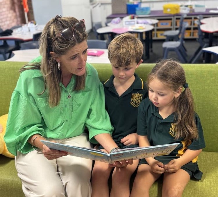 Principal reading a book to Year 1 students.