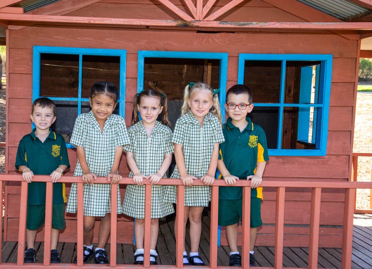 Kindergarten students on the verandah of a cubbyhouse.